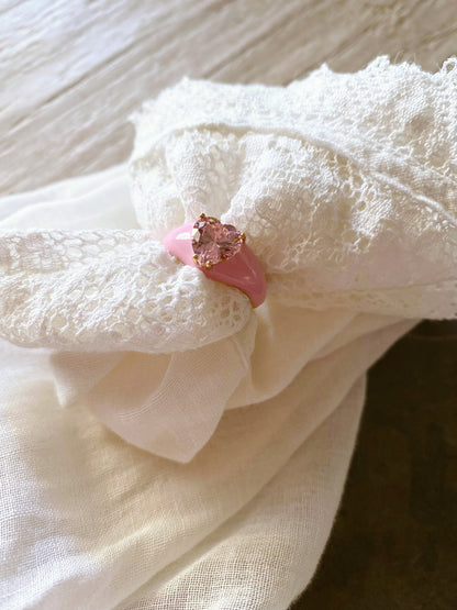 Anello in argento e smalto rosa con zircone centrale rosa a forma di cuore. Gambo regolabile