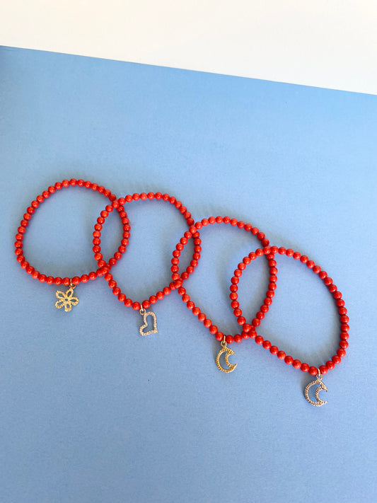 Bracciali elastici con pasta di corallo rosso e un ciondolo centrale in argento